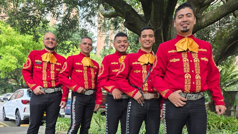 Grupo de músicos mariachis con trajes tradicionales de charro posando para un evento.